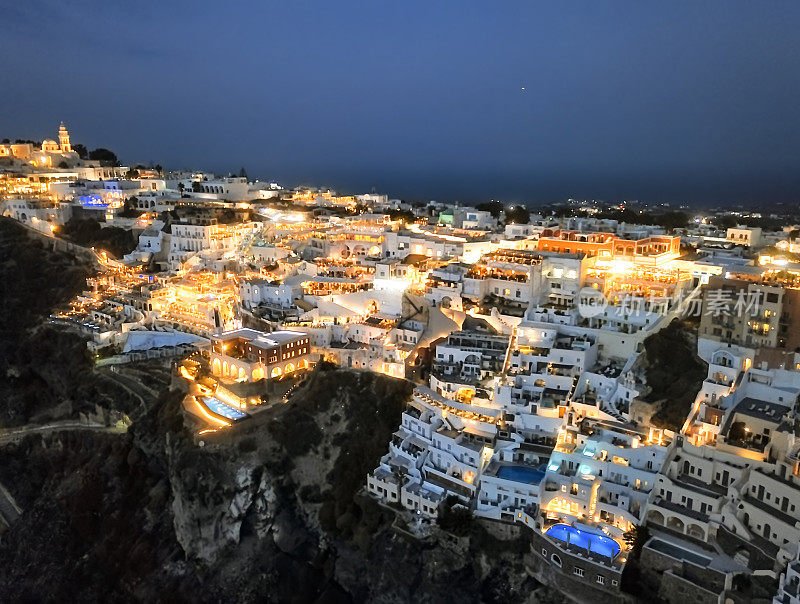 希腊圣托里尼岛Fira (Thira)镇日落时的夜间空中全景图